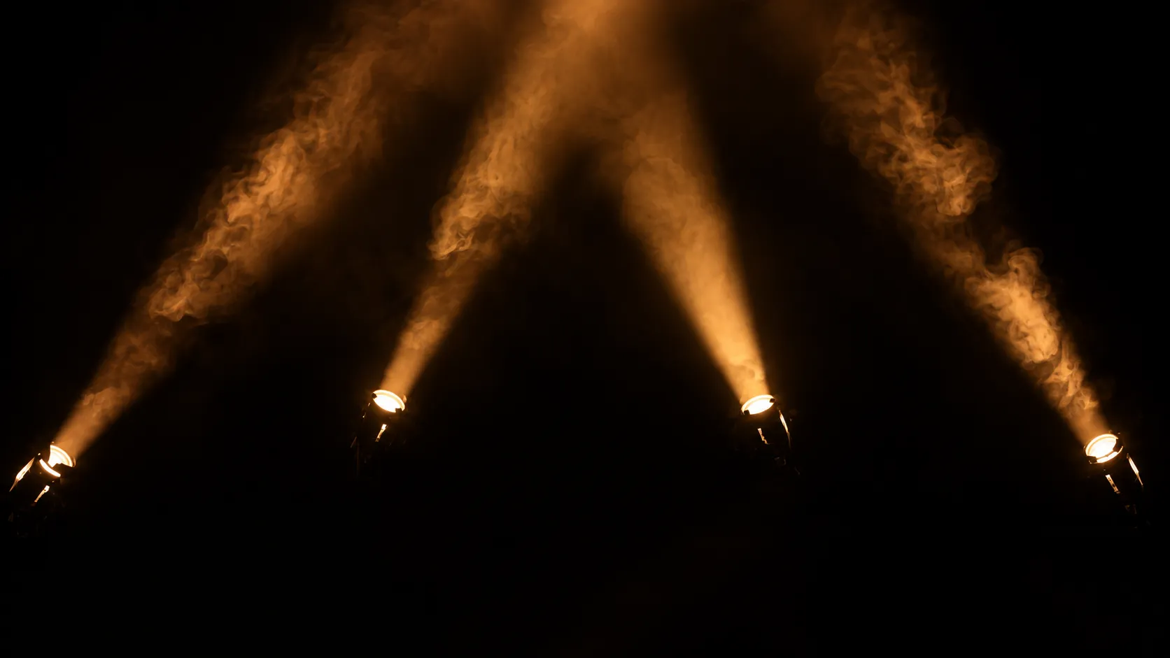 Warm stage spotlights cutting through haze above the floor at Cruise Club Cairns