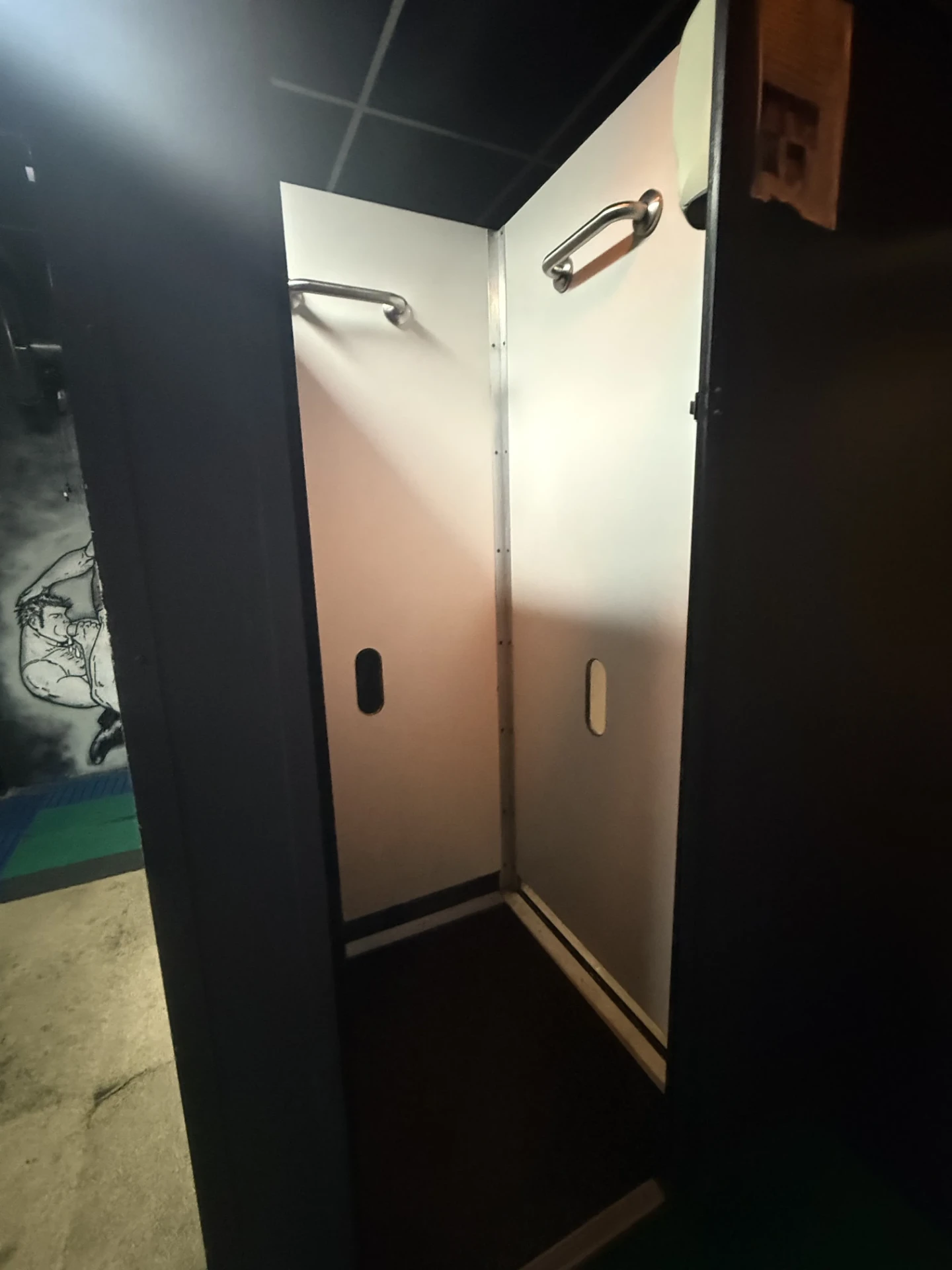 Open private cubicle at Cruise Club Cairns with pale interior panels and grab rails