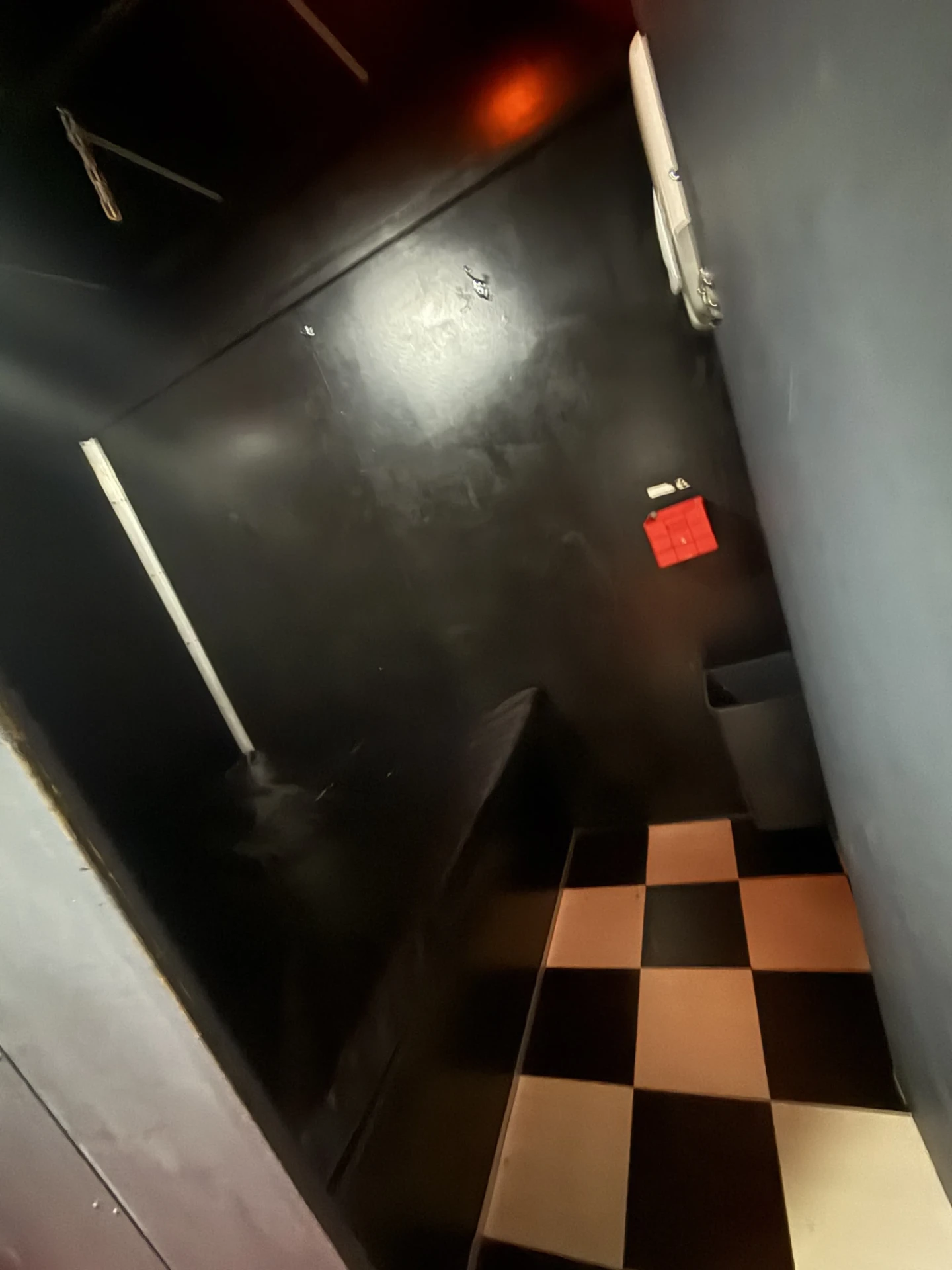 Small private room at Cruise Club Cairns with dark walls and chequered tiled flooring